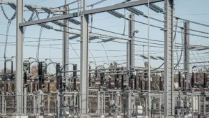 "Gardu induk listrik tegangan tinggi dengan konduktor, isolator, dan peralatan distribusi daya"