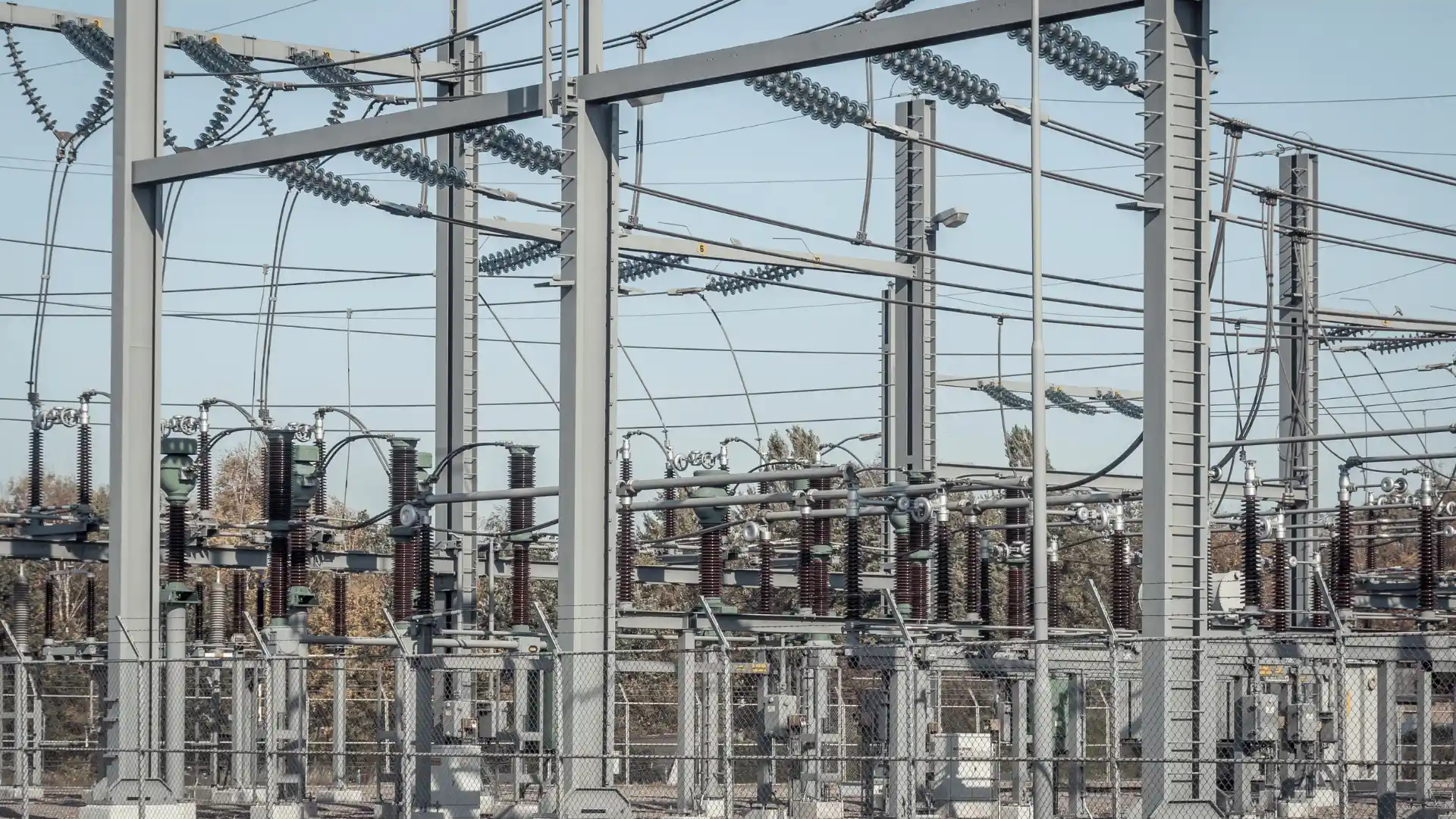 "Gardu induk listrik tegangan tinggi dengan konduktor, isolator, dan peralatan distribusi daya"